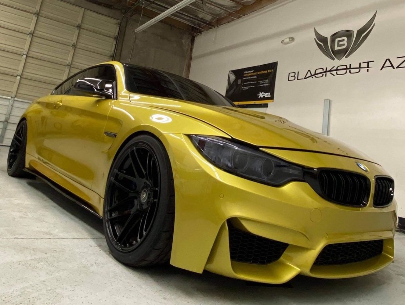 Yellow BMW with dark side glass inside the Blackout AZ Chandler shop
